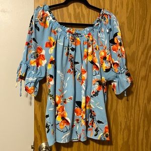 Sky blue top with flowers and round neck can be worn on/off shoulders. Sz Xl